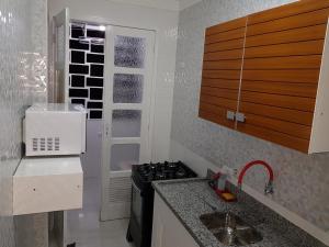 una pequeña cocina con fogones y fregadero en NAUTILUS SEAVIEW BAY-SV/SP, en São Vicente