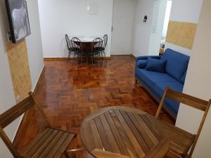 uma sala de estar com um sofá azul e uma mesa em NAUTILUS SEAVIEW BAY-SV/SP em São Vicente