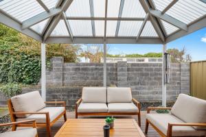 two chairs and a table under a pergola at City Two Apartment in Mount Gambier