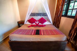 a bed with a pink bow on top of it at Ombak Dive Resort Perhentian Island in Perhentian Islands