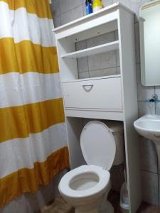 a bathroom with a white toilet and a sink at Cabañas Reflejo de Luna in Castro