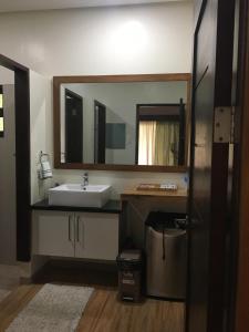 a bathroom with a sink and a large mirror at Secter Place in Oslob