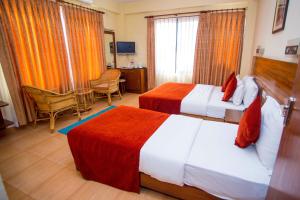 Kama o mga kama sa kuwarto sa Hotel Tara