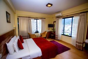 ein Schlafzimmer mit einem großen Bett mit einer roten Decke in der Unterkunft Hotel Tara in Pokhara + 37 Fotos