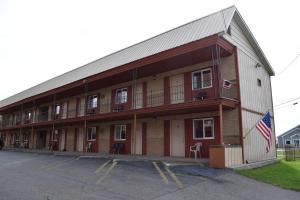 Um edifício com uma bandeira americana à frente. em Mid-City Motel em Sault Ste. Marie