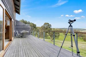 
a man standing on a balcony looking at a camera at Seascape Retreat in Victor Harbor
