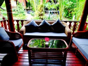 a couch sitting on a porch with a flower in a box at Starbay Samui in Koh Samui 