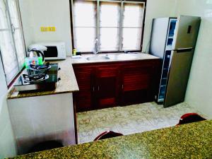 a small kitchen with a refrigerator and a sink at Starbay Samui in Koh Samui 