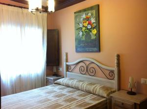 a bedroom with a bed and a painting on the wall at Posada el Mirador in Frías de Albarracín