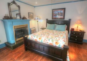 1 dormitorio con 1 cama y chimenea en Hidden Springs Bed and Breakfast, en Eureka Springs