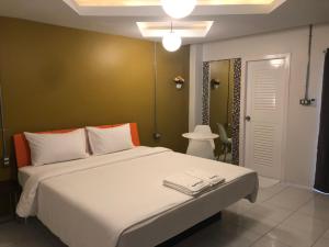 a bedroom with a large white bed in a room at The Northeast Hotel in Si Sa Ket