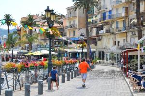 a man and a boy walking down a city street at Hôtel Méditerranée in Calvi