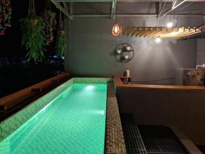 a swimming pool in the middle of a room at Kokos Hostel Padang City in Padang