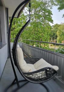 a swing chair on a balcony with a window at Julia apartments next to AQUA PARK in Druskininkai