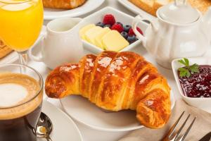 a white plate with a croissant and other breakfast foods at Hasara Hotel Galle in Galle