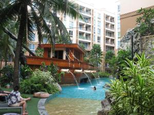 a pool at a resort with people swimming in it at Atlantis Condo Resort in Jomtien Beach