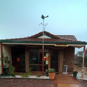 une église avec une croix sur le toit dans l'établissement Airport Whyalla Motel, à Whyalla