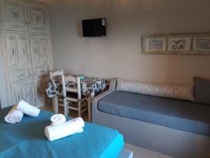 a room with two beds and a table with a chair at Ammos papanero in Agios Ioannis Pelio