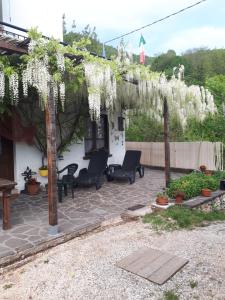 un jardín con flores blancas colgando de una pérgola en Villa Della Rocca, en Vobarno