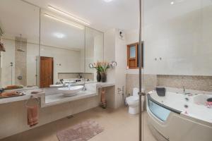 
a bathroom with a tub, sink and mirror at Cocobay Unawatuna in Unawatuna
