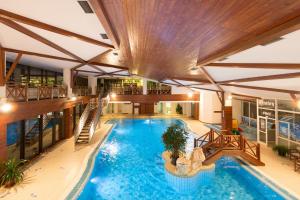 a large swimming pool in a building with a ceiling at Zrubové chaty Stará Lesná in Stará Lesná