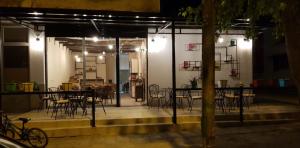 a group of tables and chairs on a patio at night at Dimitri Guest House in Përmet