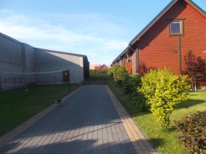 a cat walking down a brick road next to a building at Domki letniskowe U Joli - Jolanta Potrykus in Władysławowo