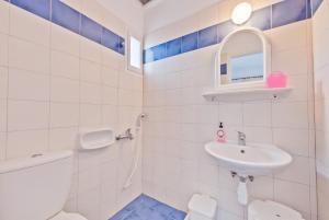Baño blanco con lavabo y aseo en Paris Rooms, en Antíparos