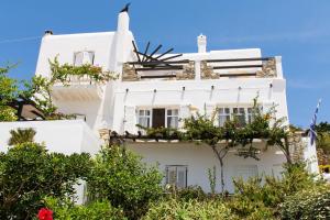 a white house with flowers on the side of it at Anchor Αpartments in Mýkonos City
