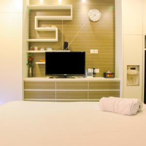 a living room with a flat screen tv on a wall at Deluxe and Modern Studio M Gold Tower Apartment By Travelio in Bekasi