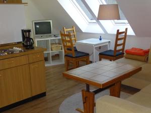 una cucina e un soggiorno con tavolo e sedie di Der Ferienhof am Meer a Fehmarn