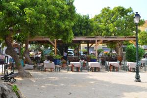 a group of tables and chairs in a park at Hôtel Méditerranée in Calvi
