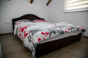 a bed with a red and white blanket on it at Nektar Park Villa Sara in Bihać