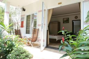 porche con 2 sillas y 1 cama en Huynh Gia Bungalow, en Phu Quoc