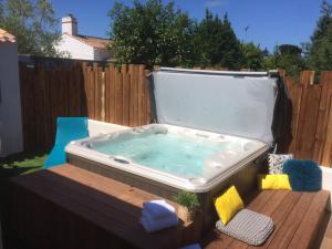 a hot tub in a backyard with a wooden fence at Résidence La Chaize in Noirmoutier-en-l'lle