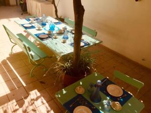 een groene tafel met groene stoelen en een plant bij Villa Majata in Realmonte