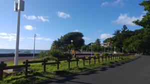 a fence on the side of a road near the beach at Appartement Blue Coast in Mahébourg