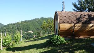 Cossano BelboにあるCorte di Langaの高台を背景にした畑の木造家屋