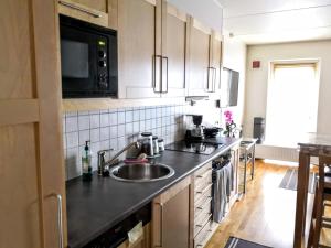 a kitchen with a sink and a microwave at Sentral moderne leilighet in Lillestrøm