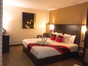 a hotel room with a large bed with red pillows at BB Mantra Boutique Hotel in Chiang Mai +56 photos