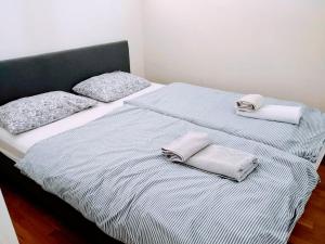 1 cama con 2 almohadas y 2 toallas. en Sentral moderne leilighet en Lillestrøm