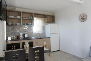 a kitchen with a refrigerator and a table and chairs at Volada Your View in Apérion +4 photos