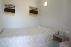 a white bedroom with a bed and a table at Volada Your View in Apérion