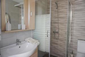 een badkamer met een douche, een wastafel en een bad bij Volada Your View in Apérion
