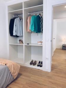 a white walk in closet with shoes in it at Piso acogedor y tranquilo - Junto a ifema y aerop. in Madrid