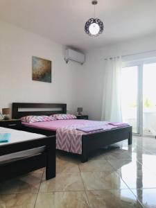 a bedroom with a large bed and a window at Suka Apartments in Ulcinj