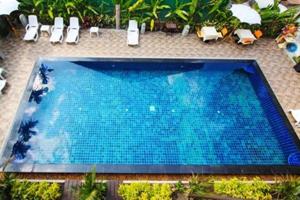 a large blue swimming pool with chairs and plants at BB Mantra Boutique Hotel in Chiang Mai