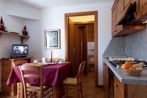 a kitchen with a table with a purple table cloth at Residence Cavallino in Ponte di Legno