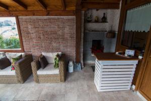 a patio with two wicker chairs and a fireplace at Tolare-Berri in Zestoa