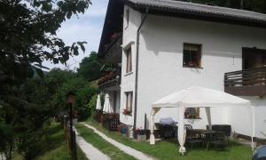 ein weißes Gebäude mit einem Schirm davor in der Unterkunft Four bedroom appartement near Bad Kleinkirchheim in Radenthein